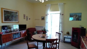 Ein Wohnzimmer mit Esstisch, Stühlen, Fernseher und Kamin.