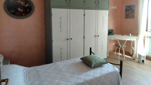 Ein Schlafzimmer mit einem Bett, einem Schreibtisch und einem Kleiderschrank.