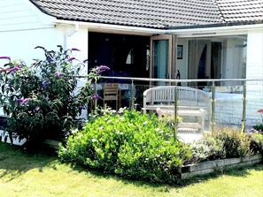 Relax in the serene garden, featuring a bench and a balcony with a view.