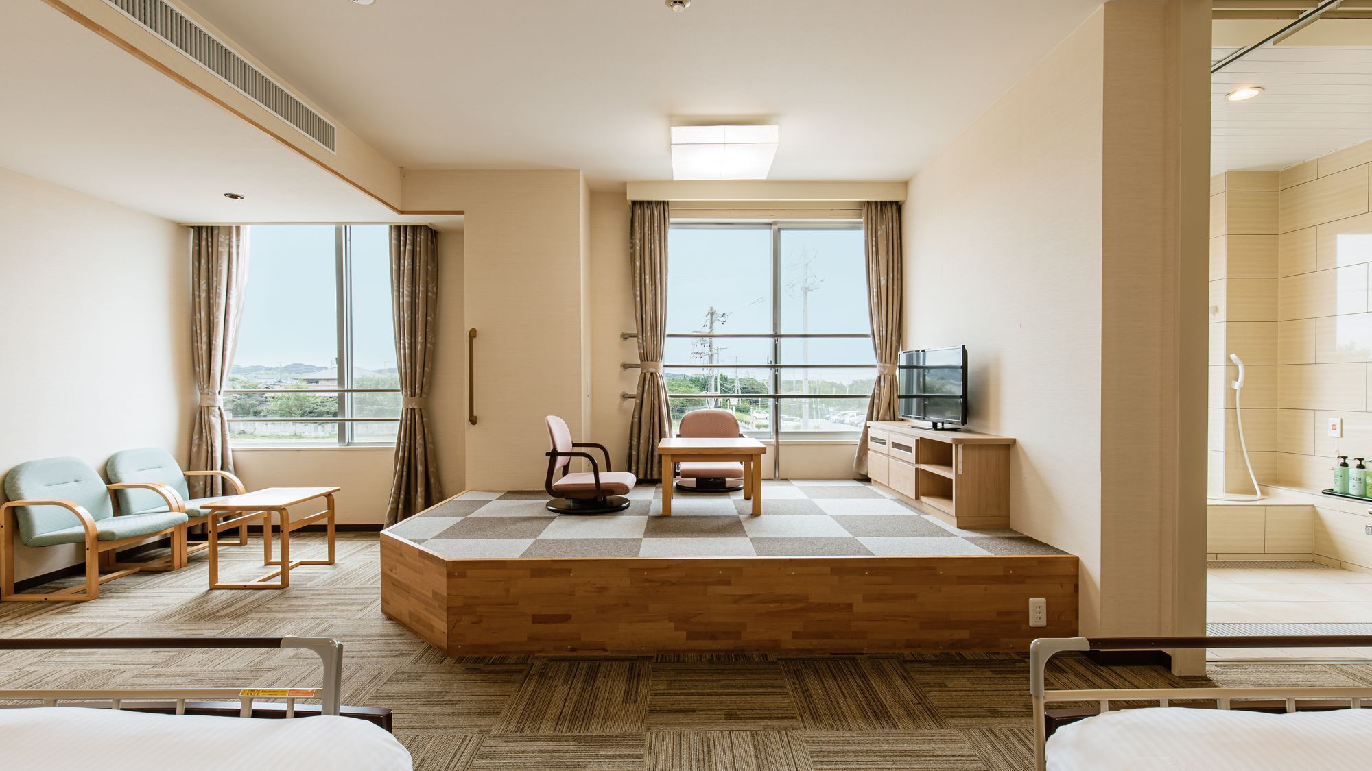 A hotel room with a checkered floor, a television, a desk, and a view of the outdoors.