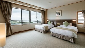 A hotel room with two beds, a large window, and a view of the outdoors.