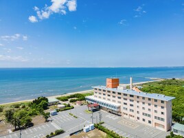 Un hotel con estacionamiento, playa y vistas al océano.