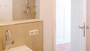 A bathroom with a sink, mirror, and shower. - comfortable apartment f. 3 pers., Central, modern furnishings, WLAN, incl. bed linen (Ostseebad Prerow)