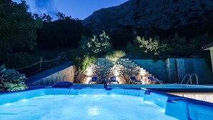Un bain à remous avec des chaises longues et un mur en pierre en arrière-plan.