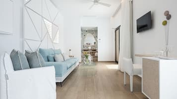 Una sala de estar moderna con un sofá, una mesa de centro y un televisor montado en la pared.