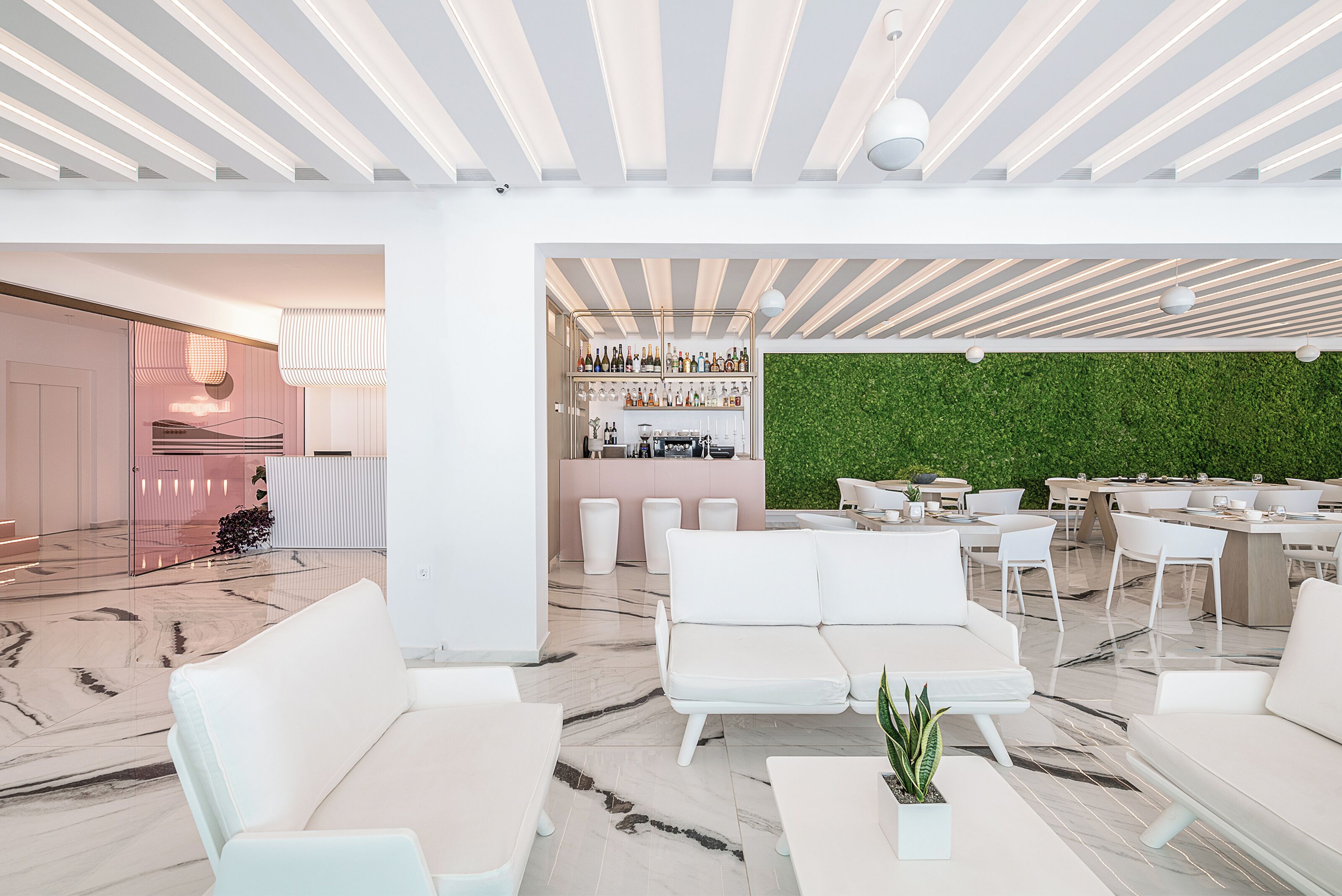 A modern interior with a bar area, seating, and a green wall.