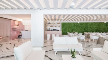 A modern interior with a bar area, seating, and a green wall.
