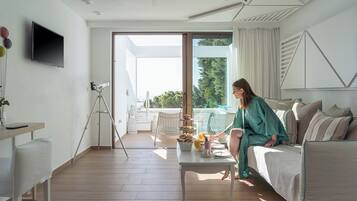 Una sala de estar moderna con un sofá, una mesita de centro con alimentos para el desayuno, un telescopio y un balcón con mobiliario exterior.