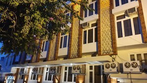 Ein mehrstöckiges Hotel mit moderner Fassade, das dekorative Paneele und Klimaanlagen aufweist.