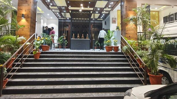 Ein Hotel mit Eingangsbereich, Treppe, Blumentöpfen und einer Rezeption.