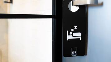 A hotel room door with a bed symbol and the number 133.