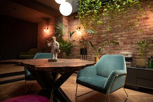 Una habitación acogedora con una pared de ladrillo rústico, una mesa de madera y un sillón azul mullido.