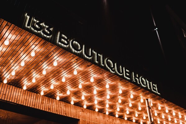 Letrero de hotel con diseño moderno y varias luces colgantes.