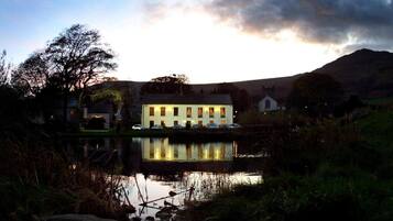 Un edificio junto al lago con varias ventanas y su reflejo en el agua.