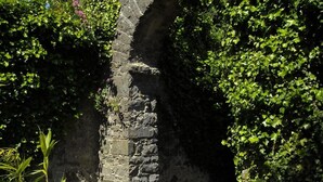 A stone archway surrounded by lush greenery. - Ghan House Carlingford (Carlingford)