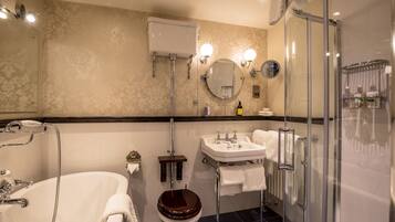 A bathroom with a bathtub, toilet, sink, and glass-enclosed shower.
