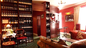 Une pièce chaleureuse dotée d’une vaste collection de vins, d’un bar et de sièges confortables.