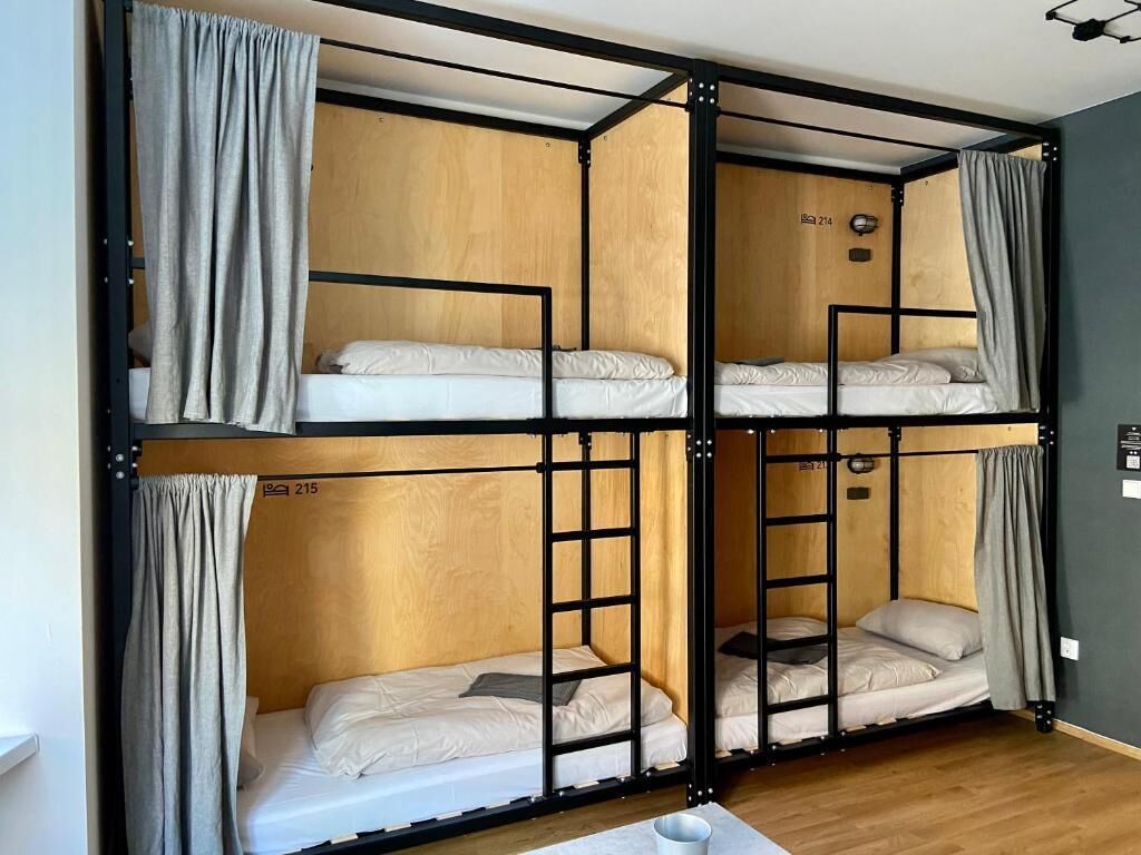 A bunk bed room with wooden panels and black metal frames.
