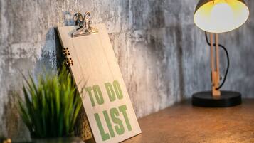 A clipboard with 'TO DO LIST' pinned to a textured wall, a desk lamp, and a small plant on a wooden surface.