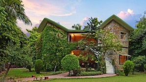 A two-story house with a green roof, surrounded by lush greenery and a well-maintained lawn. - The Fern Ranthambhore Forest Resort Sawai Madhopur, Series by Marriott (Sawai Madhopur)