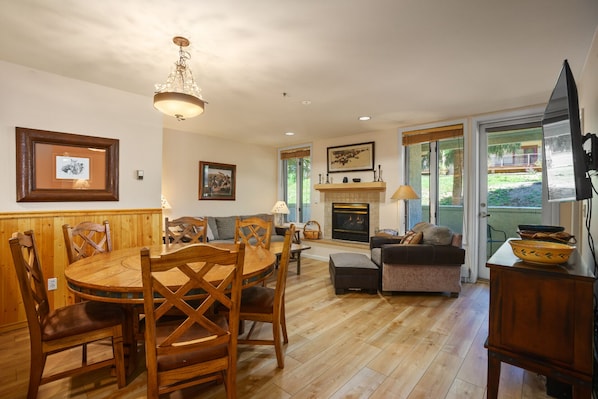 A cozy living room with a fireplace, wooden furniture, and a television.