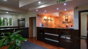 A reception area with a marble reception desk, a sign for the reception, and a sign for the toilet. - Hotel Simsir (Zlatibor)