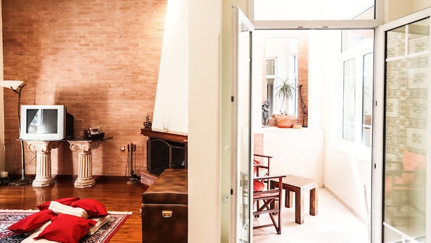 Una sala de estar con pared de ladrillo, chimenea y televisor.