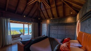 A bedroom with a large bed, a view of the ocean, and a wooden ceiling. - Villa Jade – Zen-Inspired Oceanview Estate with Spa, Cinema & Infinity Pool in St. Barths (Gustavia)