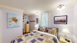 Ein Schlafzimmer mit einem Bett, einem Schminktisch, einem Nachttisch, einer Lampe und Wandbildern.