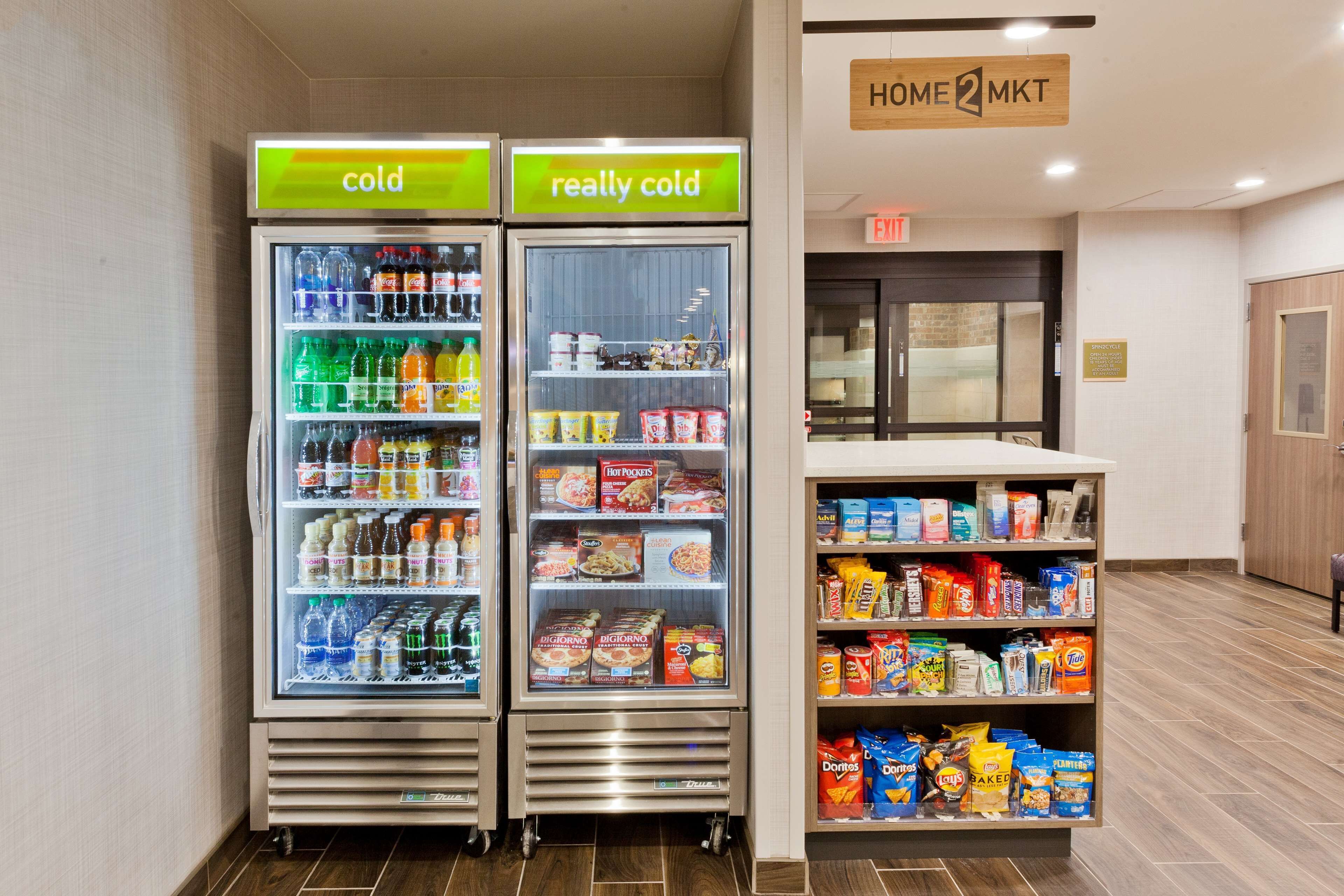 Two refrigerated beverage dispensers labeled "cold" and "really cold" with a variety of drinks and snacks.