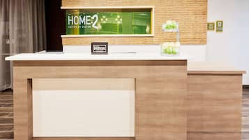 A reception desk with a sign reading "Hilton Honors" and a "HOME2" sign above it.