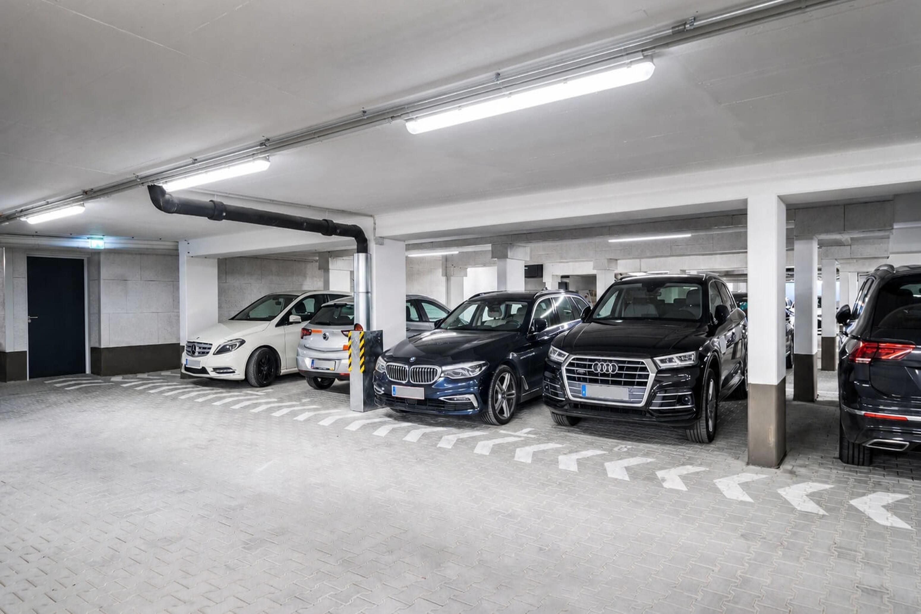 Eine mehrstöckige Tiefgarage mit parkenden Autos in dafür vorgesehenen Stellplätzen.