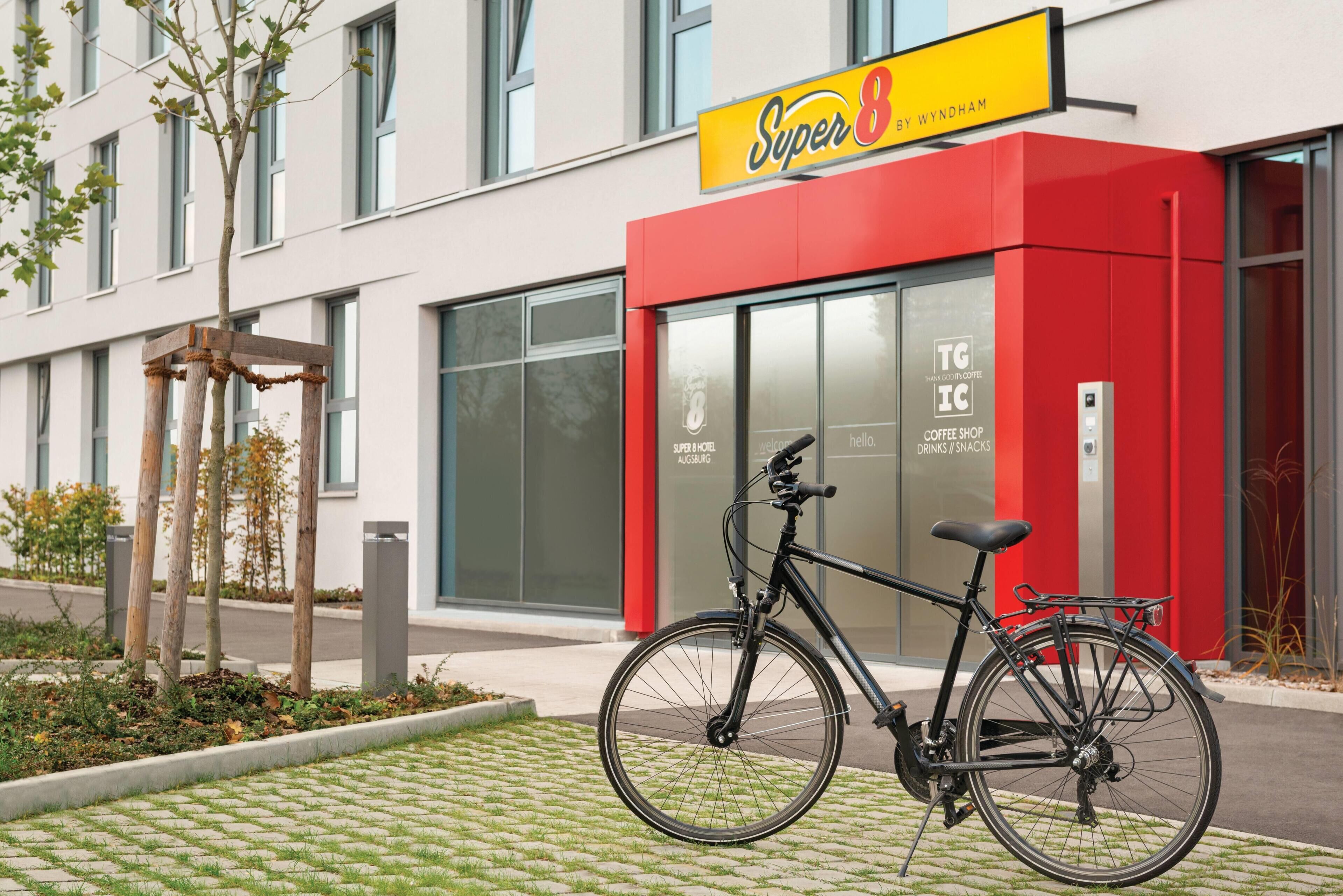 Un edificio moderno con un letrero rojo y amarillo que dice 'Super 8 by Wyndham'.