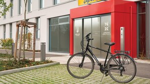 A modern building with a red and yellow sign reading 'Super 8 by Wyndham.' - Super 8 by Wyndham Augsburg (Augsburg)