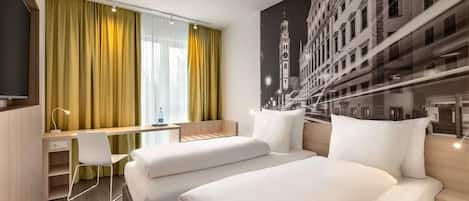 A hotel room with two beds, a desk, a chair, and a large window with curtains.