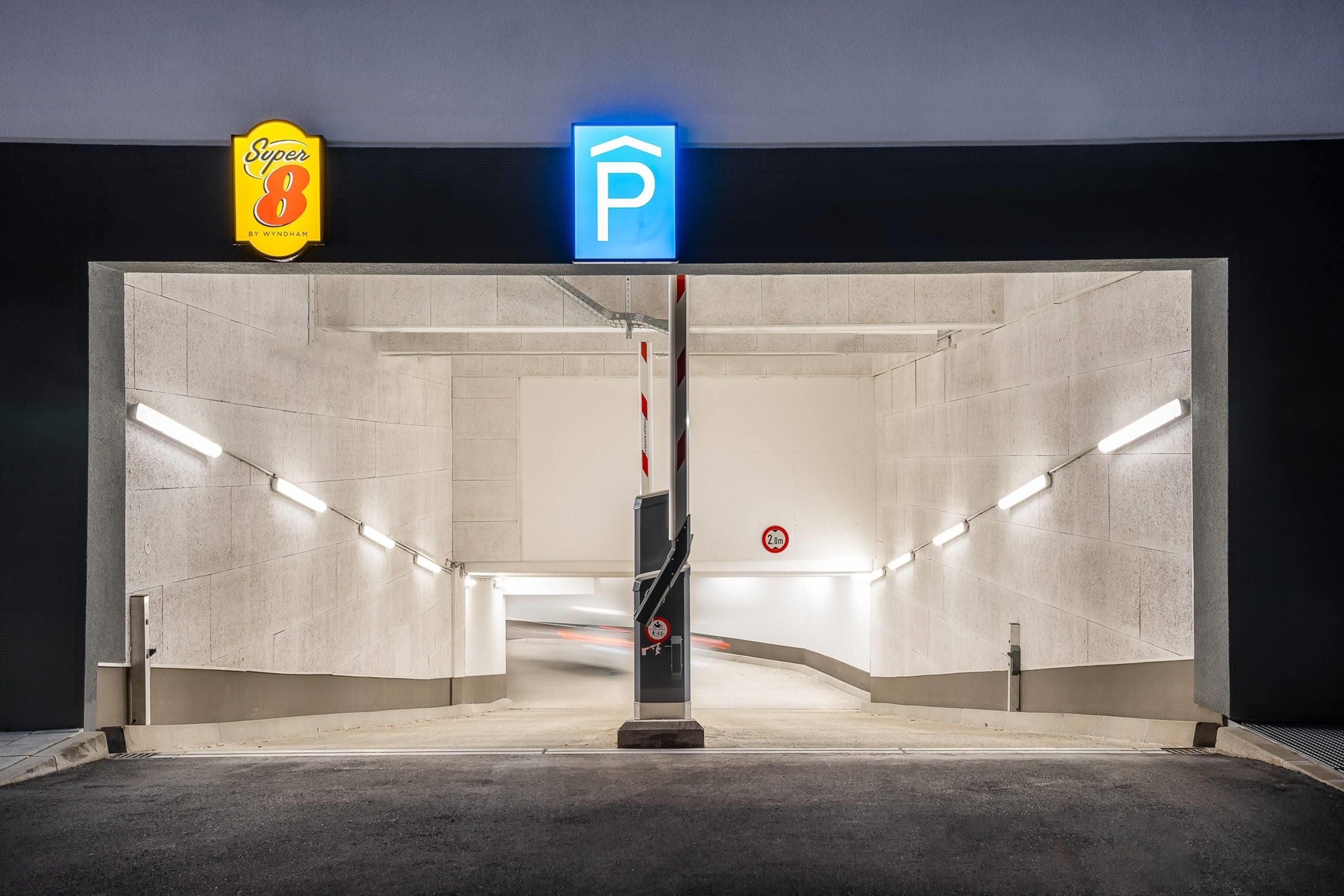 Entree van een parkeergarage met een blauw parkeerbord, een geel bord met 'Super 8' erop en een verboden parkeren bord dat een hoogte van 2,0 meter aangeeft.