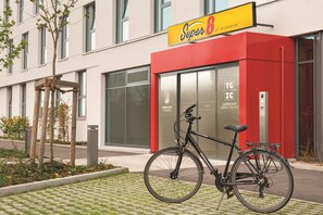 Un vélo est garé devant un immeuble sur lequel on peut lire l’inscription « Super 8 by Wyndham ».