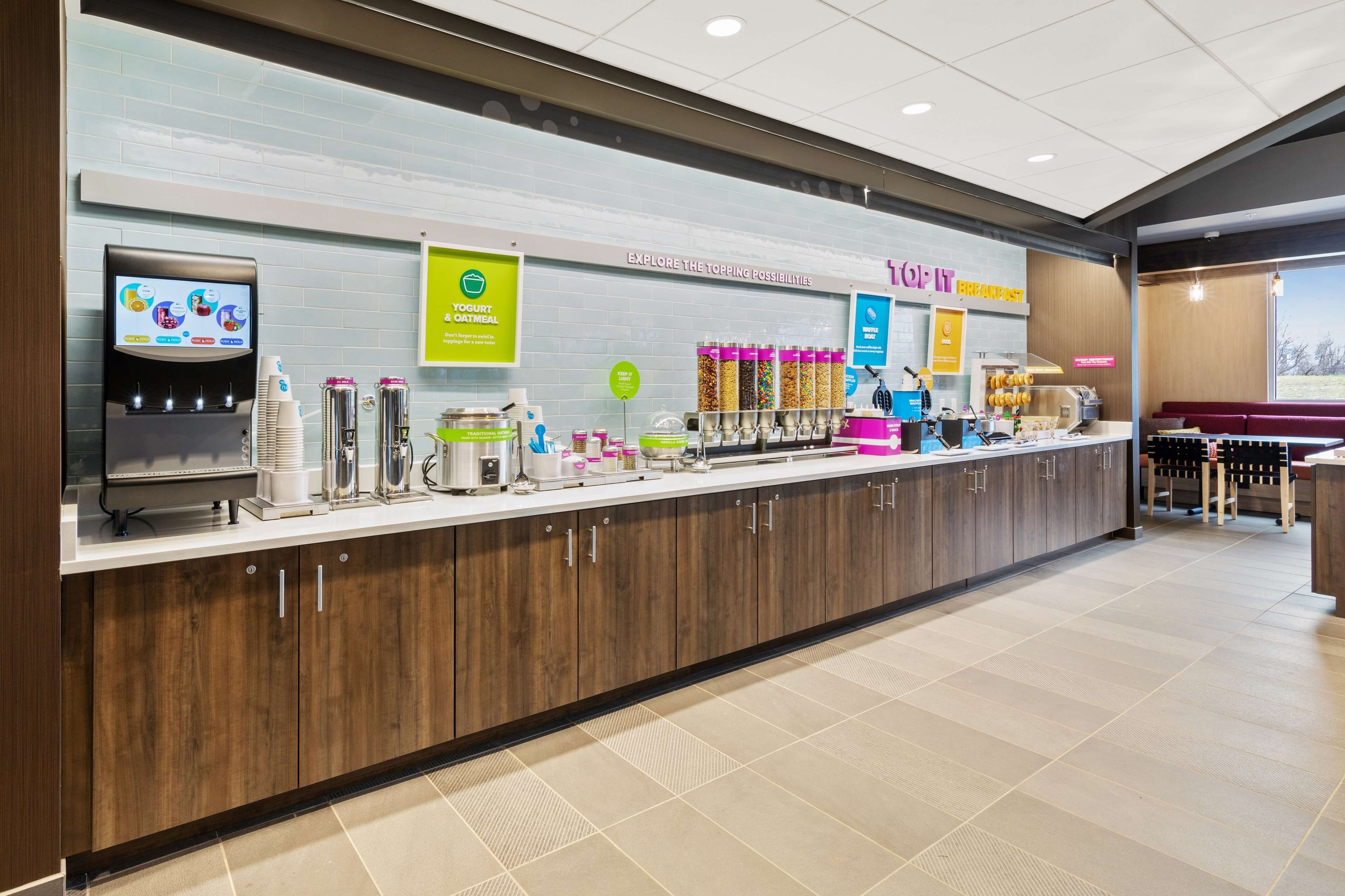 Un bar pour le petit-déjeuner équipé d’un distributeur de yaourt, d’une machine à café et de différents récipients pour aliments.