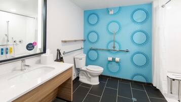 A modern bathroom with a white sink, a toilet, and a shower area.