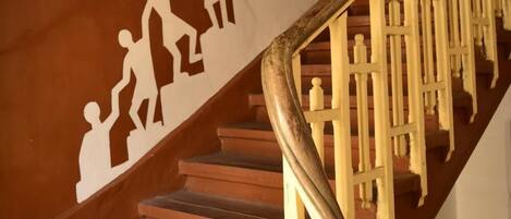 A wooden staircase with a handprint mural on the wall.