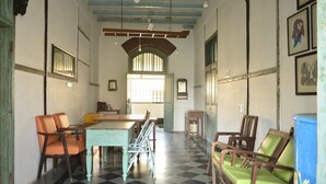 Quarto com piso xadrez, móveis de madeira e uma grande janela com vidro de barras.