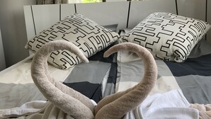 Una cama con almohadas y toallas dispuestas en forma de cisne.