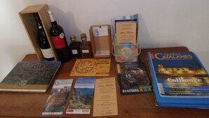 Ein Holztisch mit verschiedenen Gegenständen, darunter Bücher, eine Weinflasche und eine Speisekarte.