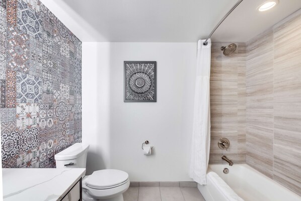 Un baño con inodoro, lavamanos y bañera.