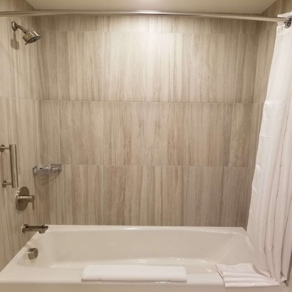 A modern bathroom with a bathtub, a showerhead, and a towel rack. - The Cassara Carlsbad, Tapestry Collection by Hilton (Carlsbad)