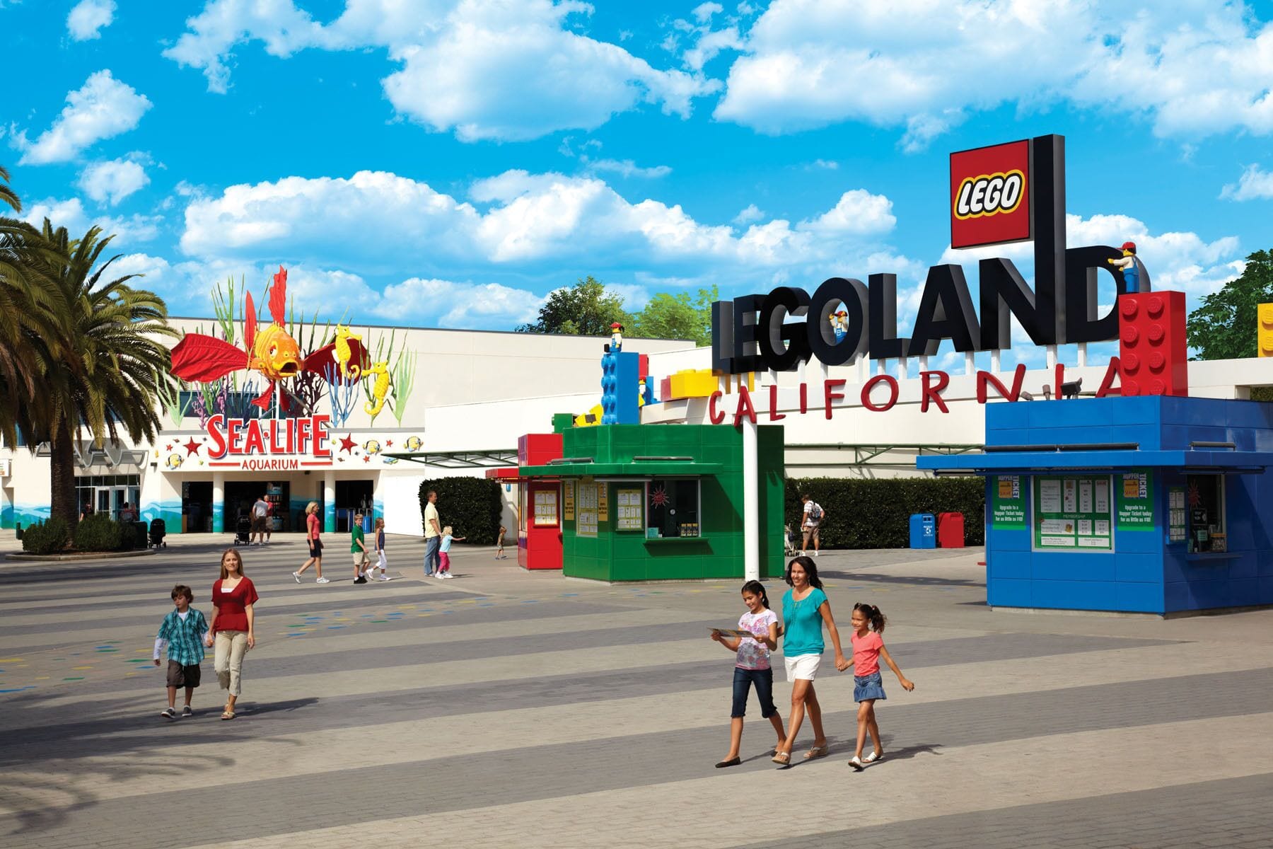 Une place sur le thème de LEGO, avec un aquarium Sealife et un panneau indiquant l’entrée de LEGOLAND California.
