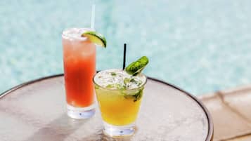 Deux boissons sur une table, près d’une piscine.