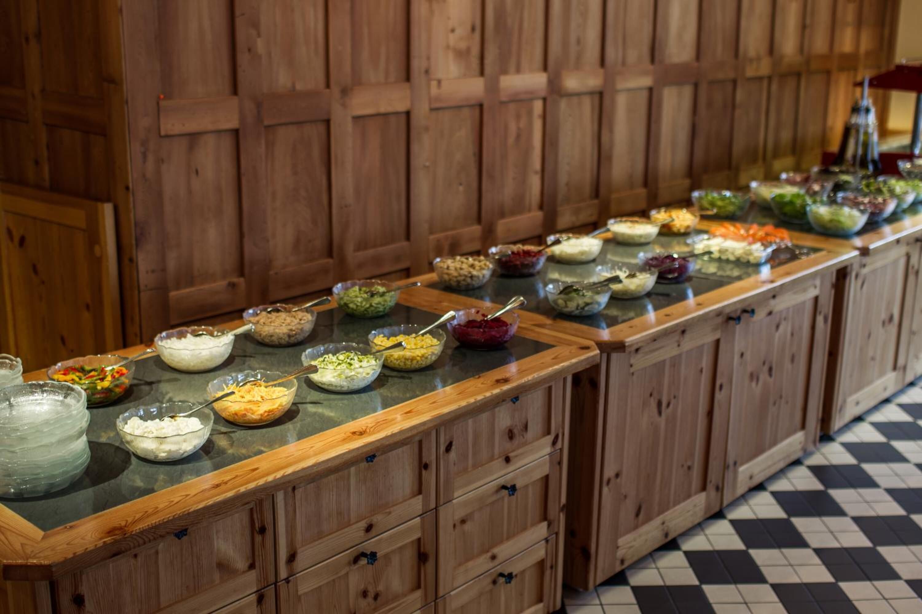 Buffet com diversos pratos e um armário de madeira com gavetas.
