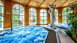 Un espace spa comprenant un bain à remous et une statue de femme.