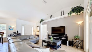 A modern living room with a sectional sofa, a flat-screen TV, and a coffee table.